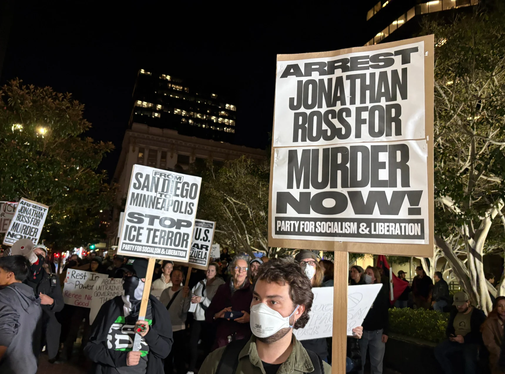 Un manifestante sostiene un cartel que dice "¡Arresten a Jonathan Ross por asesinato ahora!" en una protesta en el centro de San Diego, California, el 8 de enero de 2026.